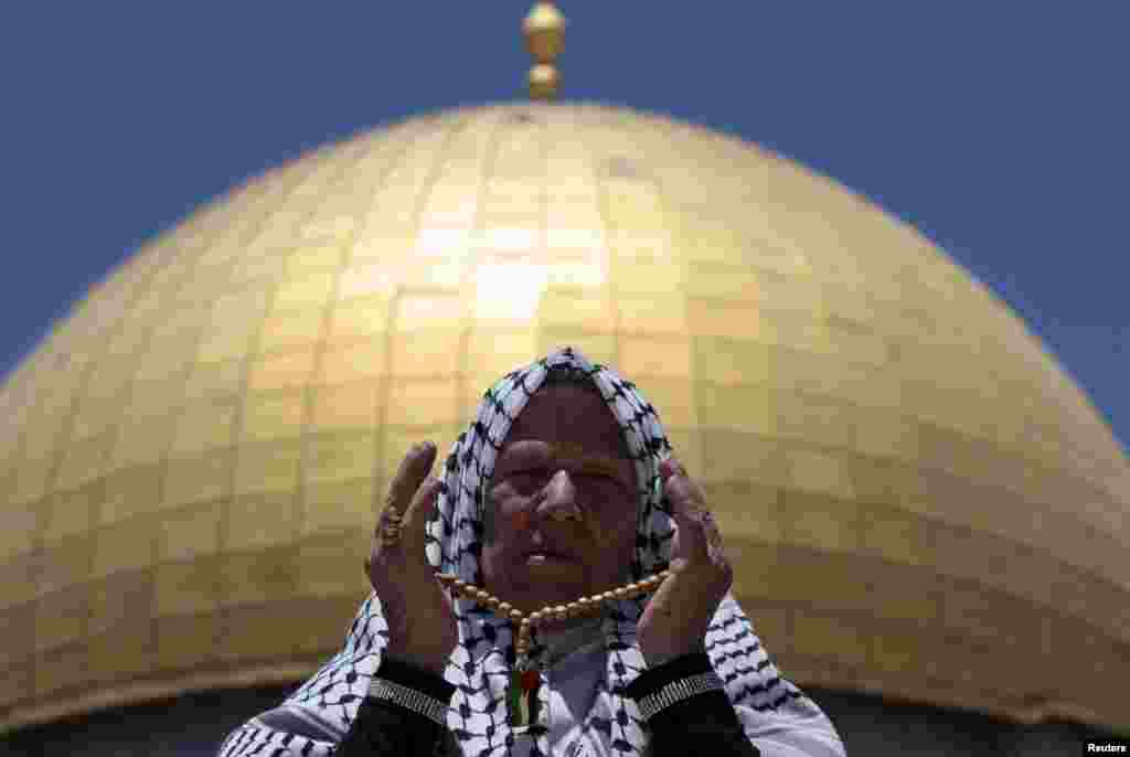 Seorang warga Palestina berdoa di depan Masjid Kubah Batu (Dome of the Rock) pada wilayah yang disebut kaum Muslim sebagai Al-Haram asy-Syarif (Noble Sanctuary) namun orang Yahudi menyebutnya sebagai Bait Allah (Temple Mount) di kota tua Yerusalem, dalam bulan suci Ramadan, 26 Juli 2013.