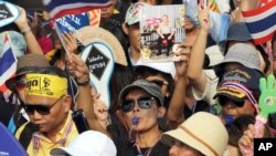 Aksi unjuk rasa anti-pemerintah membawa gambar Raja Bhumibol Adulyadej, dan meneriakkan slogan memprotes RUU amnesty di Bangkok, Thailand (11/11).