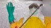 A health worker is sprayed with disinfectant after he worked with patients that contracted the Ebola virus, at a clinic in Monrovia, Liberia, Monday, Sept. 8, 2014. Border closures, flight bans and mass quarantines are creating a sense of siege in the W