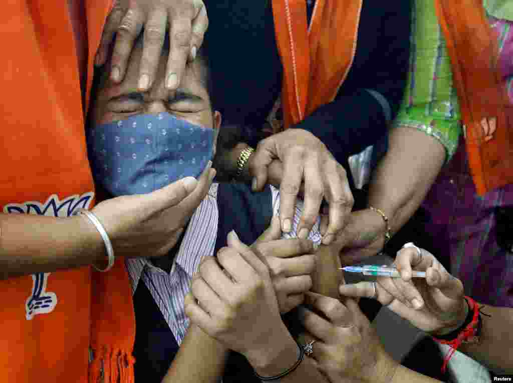 A girl reacts as she receives a dose of Bharat Biotech's COVID-19 vaccine, Covaxin, during a vaccination drive for children aged 15-18 years in Ahmedabad, India.