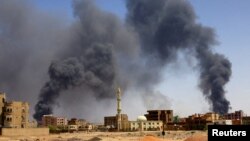 FILE PHOTO: Mtu akitembea wakati moshi ukitanda juu ya majengo baada ya shambulizi la angani Khartoum Kaskazini.