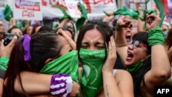 Para pengunjuk rasa pro-aborsi mengenaka kain hijau merayakan pengesahan undang-undang yang melegalkan aborsi di luar Kongres Argentina, di Buenos Aires, 30 Desember 2021. 