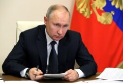 FILE - Russian President Vladimir Putin chairs a meeting via a video conference at Novo-Ogaryovo state residence, Dec. 23, 2020. (Sputnik/Mikhail Klimentyev/Kremlin via Reuters)