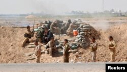 Volunteers with Kurdish peshmerga forces clash with Islamic State militants in the town of Daquq, south of Kirkuk, Sept. 30, 2014. 