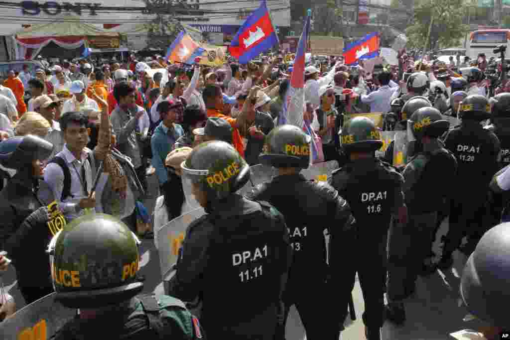 Polisi anti huru hara memblok demonstran yang dipimpin oleh pembela HAM Mam Sonando, yang meminta pemerintah memberikan ijin pendirian saluran televisi baru di Phnom Penh, 27 Januari 2014.