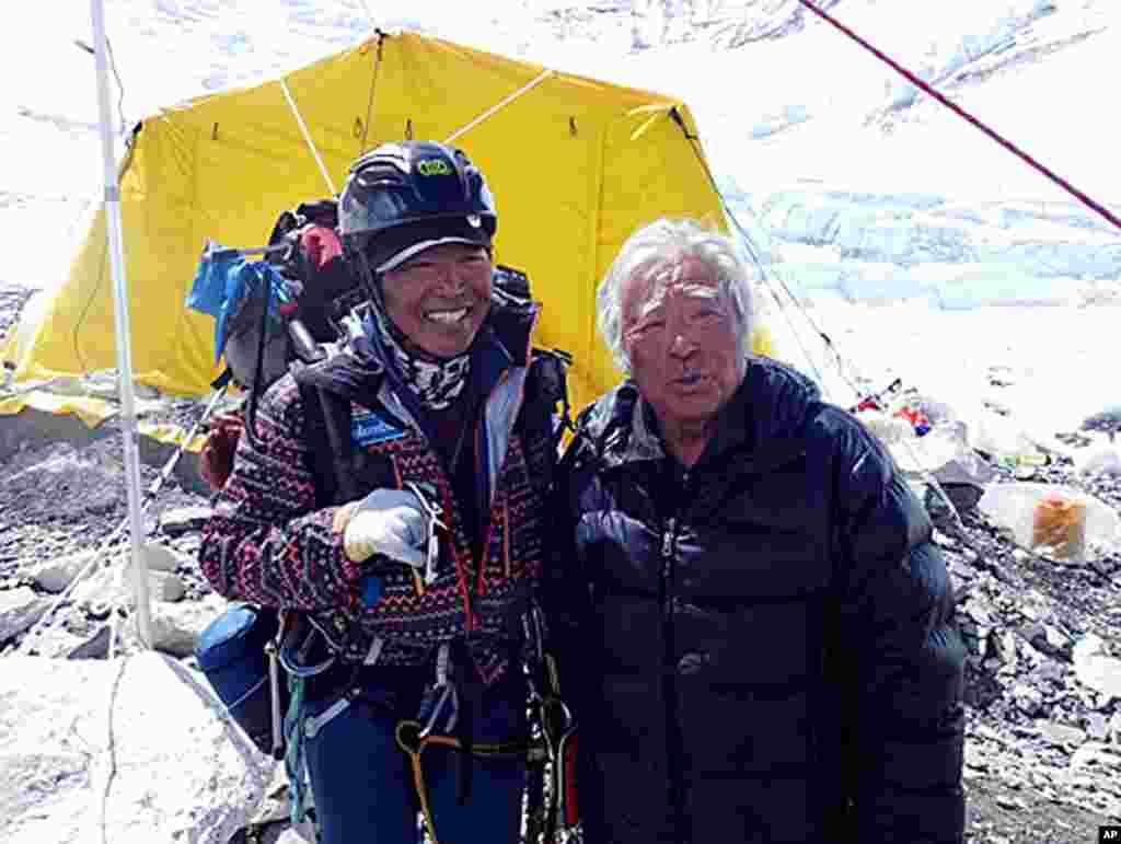 Yuichiro Miura, right, is greeted by his friend climber Kenji Kondo while resting at his camp at 6,500 meters during his attempt to scale the summit of Mount Everest, May 18, 2013. (AP Photo/Miura Dolphins)