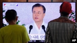 People watch a TV screen showing a live broadcast of South Korean President Moon Jae-in's speech during a ceremony to celebrate the Korean Liberation Day, marking the 74th anniversary of Korea's liberation from the Japanese colonial rule, at the…