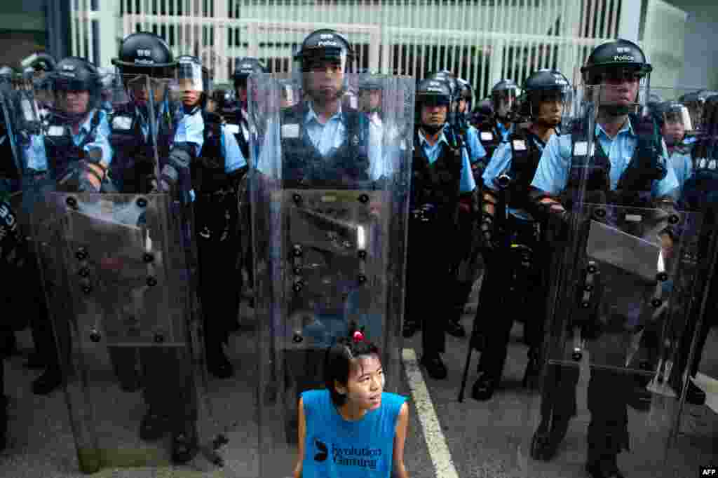 2019年6月12日,香港立法會外,一名抗議者坐在防暴警察面前。