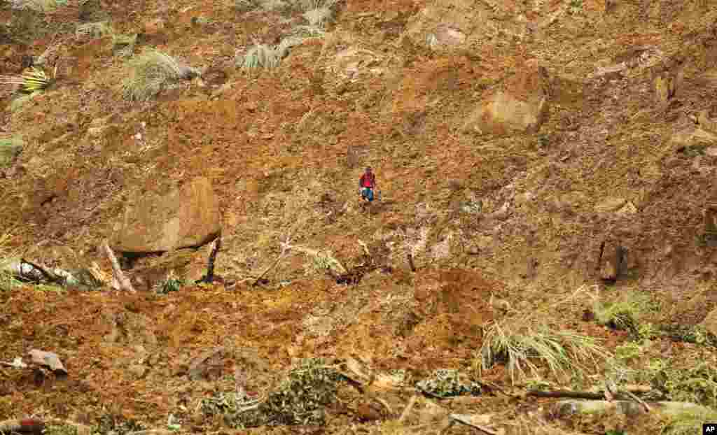 A Sri Lankan man navigates his way through mud and sludge caused by a mudslide at the Koslanda tea plantation in the Badulla district, about 220 kilometers east of Colombo, Sri Lanka, Oct. 30, 2014.