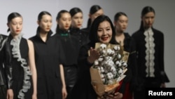 時裝設計師周麗在北京舉行的中國國際時裝週上懷抱一把棉花做出的花束表達對新疆棉的支持。 （2021年3月30日）