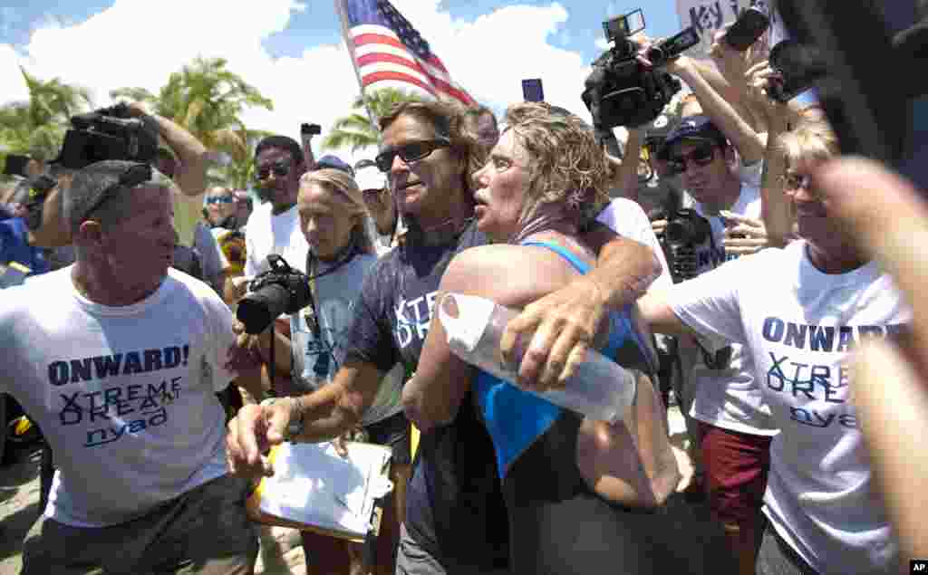 Endurance swimmer Diana Nyad, right, and her trainer, Bonnie Stoll hug after Nyad walks ashore in Key West, Florida, Sept. 2, 2013.