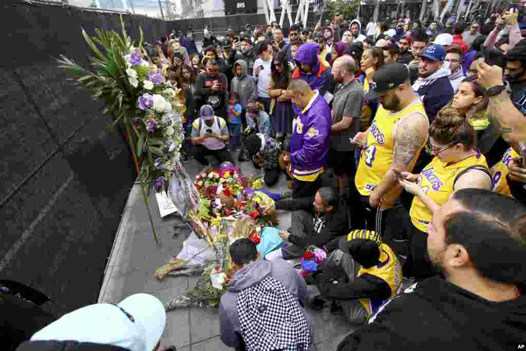 Fans of Kobe Bryant mourn at a memorial to him in front of Staples Center, home of the Los Angeles Lakers, after word of the Lakers star's death in a helicopter crash, in downtown Los Angeles, Jan. 26, 2020.