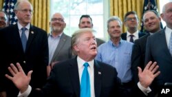 Presiden Donald Trump ditemani Menteri Pertanian Sonny Perdue (kanan), para petani dan peternak, berbicara di Gedung Putih, Washington, 23 Mei 2019.

