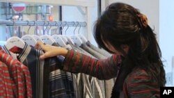 Afghan fashion designer Zolaykha Sherzad looks through clothing from her label Zarif Designs at a London boutique