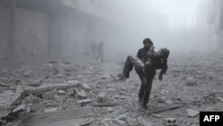 A wounded man is carried following an air strike on the rebel-held besieged town of Arbin, in the eastern Ghouta region on the outskirts of the capital Damascus on January 2, 2018.