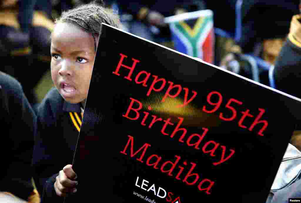 Children hold placards as they gather to wish Nelson Mandela happy birthday at a township school in Atteridgeville, near Pretoria, July 18, 2013.
