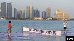 Dalam foto yang dikeluarkan ATP ini, Rafael Nadal, kiri, dan Roger Federer bermain di lapangan tenis khusus di atas Teluk Persia untuk mempromosikan turnamen tenis Qatar Terbuka. Kedua petenis melaju ke babak semifinal.