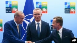 Presiden Turki Recep Tayyip Erdogan (kiri) menjabat tangan Perdana Menteri Swedia Ulf Kristersson (kanan) ketika bertemu menjelang KTT NATO di Vilnius, Lituania, pada 10 Juli 2023. (Foto: Yves Herman, Pool Foto via AP)