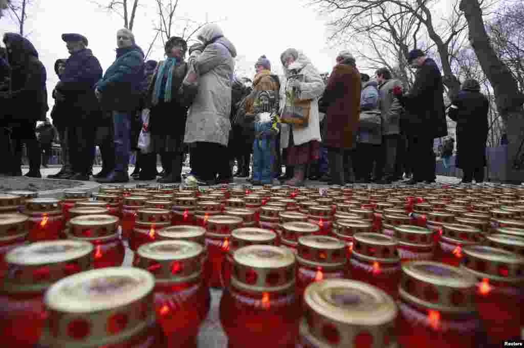Lit candles are placed on the ground as people gather to attend a memorial service before the funeral of Russian leading opposition figure Boris Nemtsov, in Moscow, March 3, 2015.