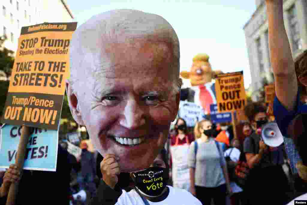 Un hombre sostiene un recorte de cartón del candidato demócrata a la presidencia de EE.UU., Joe Biden, durante una marcha desde la plaza McPherson hasta la Casa Blanca después del día de las elecciones en Washington, D.C., el 6 de noviembre de 2020.