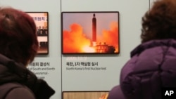 Para pengunjung menonton foto yang memperlihatkan peluncuran rudal Korea Utara di Unification Observation Post di Paju, Korea Selatan, dekat perbatasan dengan Korea Utara, 13 Desember 2019. (Foto: AP)