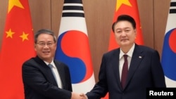 윤석열 한국 대통령이 26일 제9차 한일중 정상회의 참석차 방한한 리창 중국 국무원 총리와의 회담에 앞서 악수하고 있다.