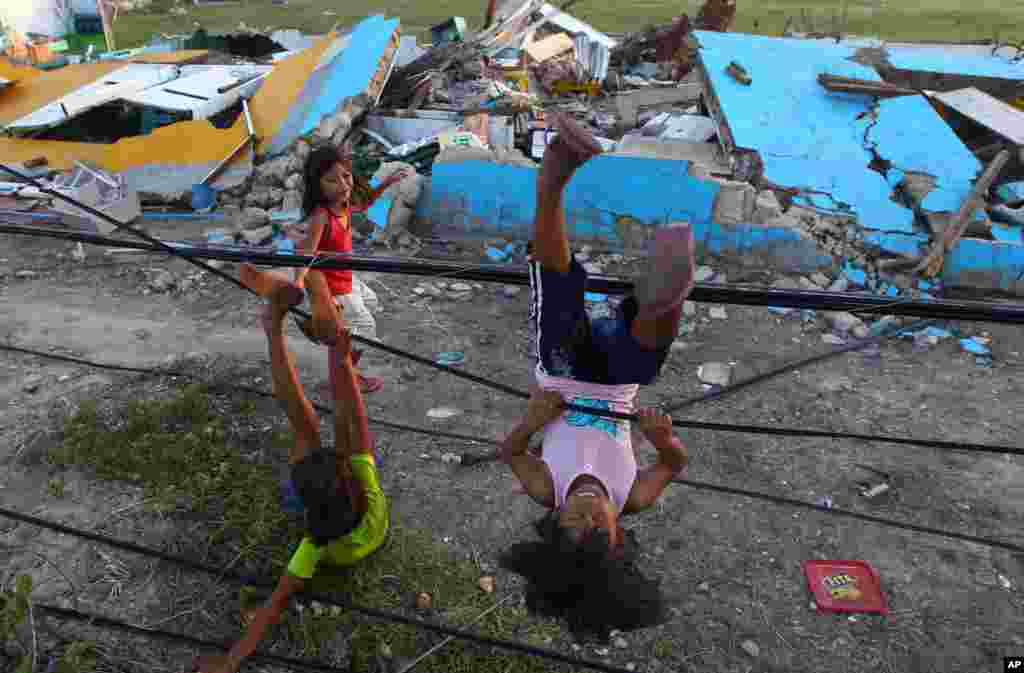 Survivors of Typhoon Haiyan play with fallen power lines near a damaged school in Guiuan, Philippines, Nov. 14, 2013. 