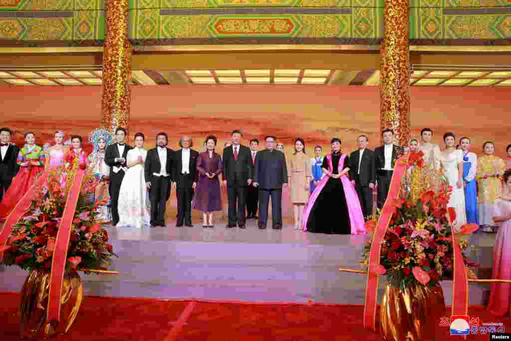 北京为朝鲜领导人金正恩一行举行文艺演出后,演员和两国元首和夫人合影。其中有不少女艺人。彭丽媛左侧的一身白衣者似乎是其爱徒、歌唱家雷佳。金正恩夫人右侧是歌唱家殷秀梅(朝鲜中央通讯社2018年3月28日发布的日期不详的照片)。