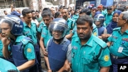 পুলিশ সদস্যরা একাত্তর টেলিভিশনের শাকিল আহমেদ এবং ফারজানা রুপাকে চিফ মেট্রোপলিটন ম্যাজিস্ট্রেটের আদালতে নিয়ে যাচ্ছেন। ২২ আগস্ট, ২০২৪, ঢাকা।