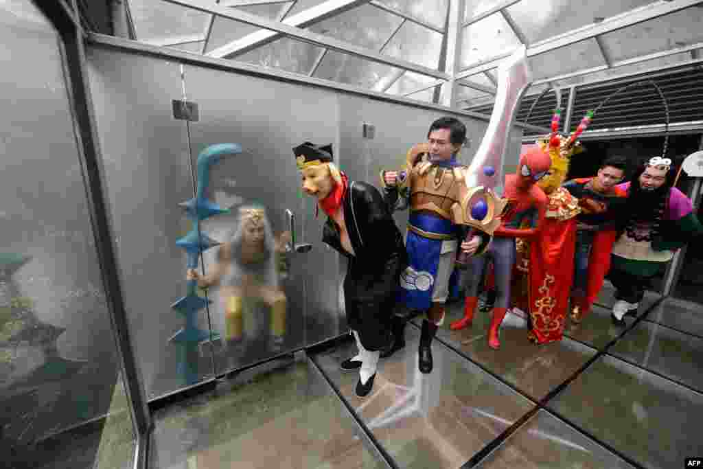 Para aktor dengan kostum karakter komik dan film berfoto di toilet umum kaca untuk memperingati Hari Toilet Dunia, di Changsha, Hunan, China.
