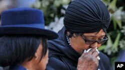 FILE - Winnie Madikizela-Mandela, Nelson Mandela's former wife, walks away after paying her respect to former South African President Nelson Mandela during the lying in state at the Union Buildings in Pretoria, South Africa, Dec. 11, 2013.