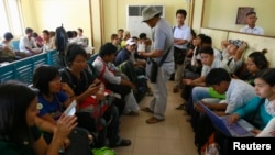 FILE - Non-governmental Organizations (NGOs) and International Non-governmental Organizations (INGOs) staff wait at Sittwe Airport to return to Rangoon, in Sittwe, March 28, 2014.