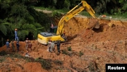 Rescuers work during a rescue and evacuation operation following a landslide at a campsite in Batang Kali