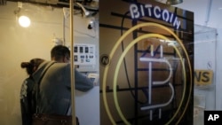 In this Friday, Dec. 8, 2017, photo, people use the Bitcoin ATM in Hong Kong. (AP Photo/Kin Cheung)