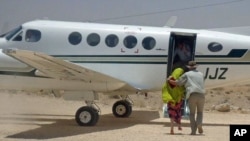 British hostage Judith Tebbutt (L) is escorted to a plane at Adado airport after she was released in central Somalia, March 21, 2012.