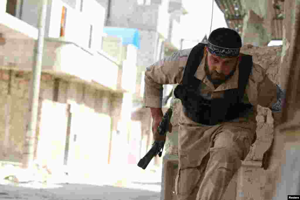 A Free Syrian Army fighter runs for cover near Nairab military airport in Aleppo, Syria, June 12, 2013.