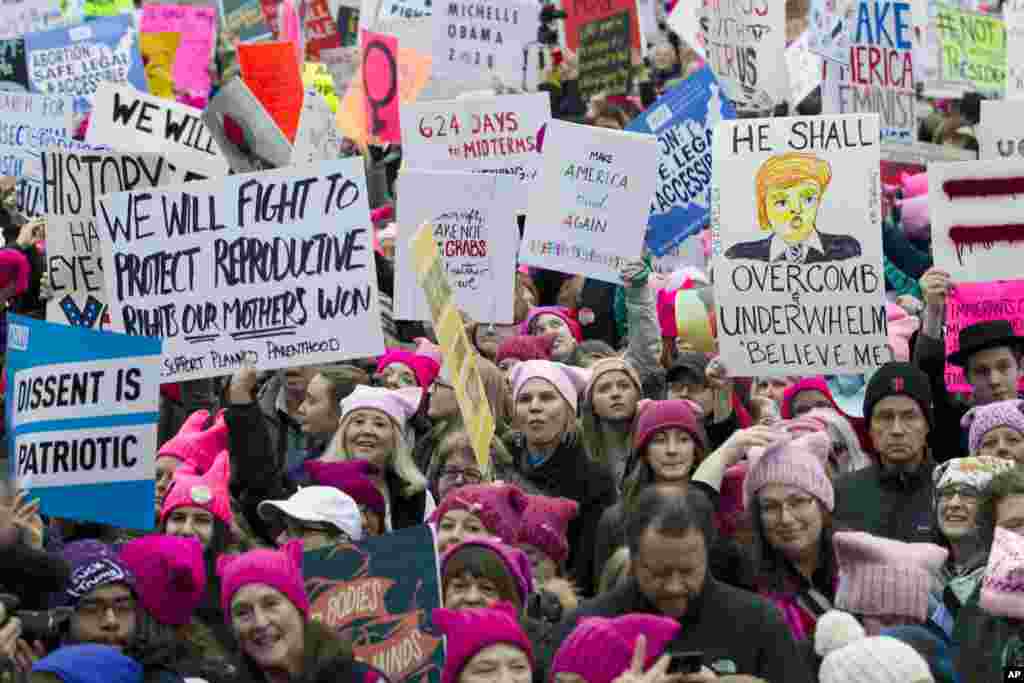 Women with pink hats and signs begin to gather early and are set to make their voices heard on the first full day of Donald Trump's presidency, Jan. 21, 2017 in Washington. (AP Photo/Jose Luis Magana)