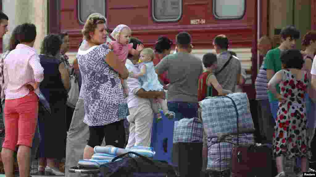 Passengers wait before boarding a train heading to Moscow at a railway station in Donetsk, eastern Ukrainian, Aug. 10, 2014.