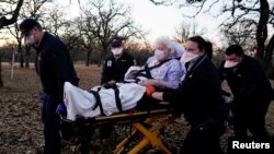 Des ambulanciers transportent une femme de 87 ans qui avait été exposée à la maladie COVID-19 à Meeker, Oklahoma, aux États-Unis, le 20 décembre 2020.