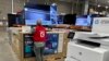 An associate checks over a big-screen television on display in a Costco warehouse Feb. 6, 2024, in Colorado Springs, Colorado. The U.S. Labor Department reported on Feb. 13 that the consumer price index rose 0.3% from December to January.