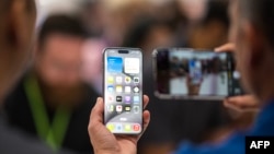 Seseorang melihat Apple iPhone 15 Pro saat acara peluncuran di Apple Park di Cupertino, California, 12 September 2023. (Foto: Nic Coury/AFP)