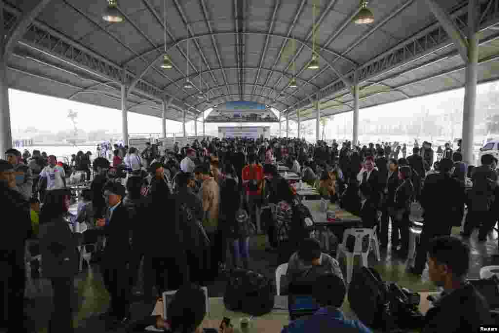Election commission officers and candidates gather during a registration of election candidates near the Government complex in Bangkok.