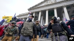 Para anggota kelompok ekstremis Oat Keepers berdiri di area timur Gedung Capitol, di Washington, dalam serangan yang dilancarkan para pendukung Donald Trump pada 6 Januari 2021. (Foto: AP/Manuel Balce Ceneta)
