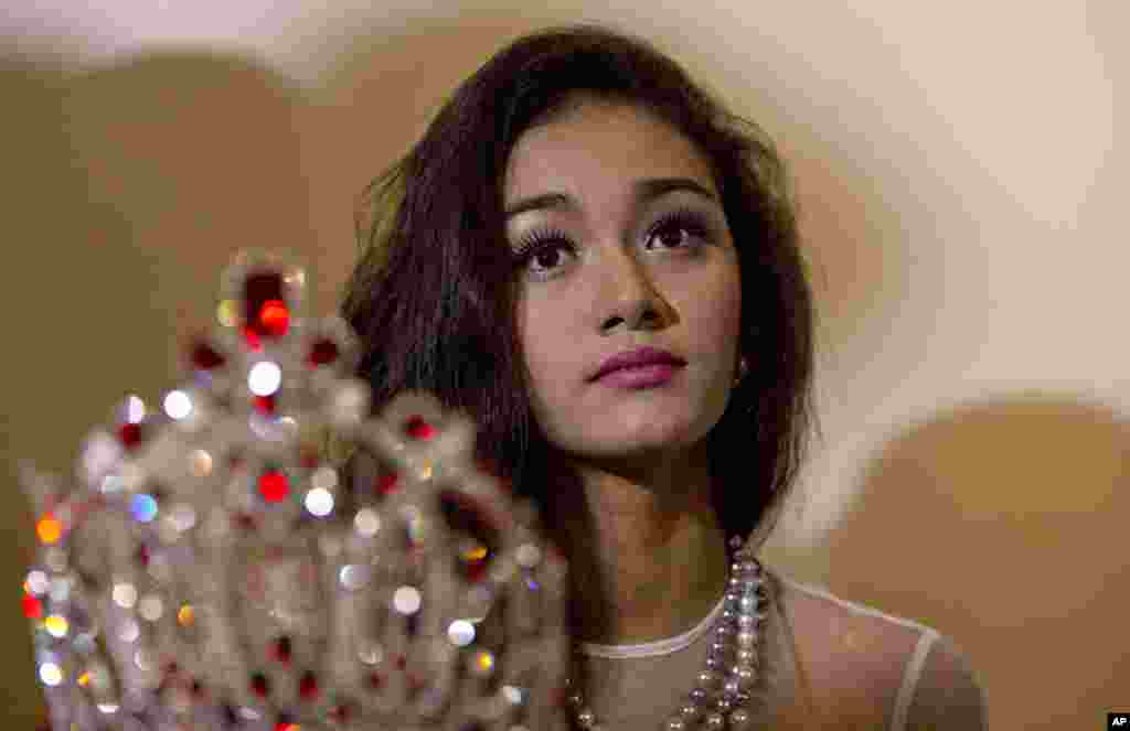May Myat Noe, Myanmar's first international beauty queen, winner of the 2014 Miss Asia Pacific World, sits with her crown that she allegedly ran away with, during a press conference in Yangon, Myanmar, Sept. 2, 2014.