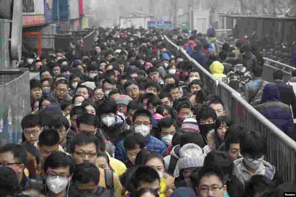 2015年12月8日，在北京首次发布空气污染红色警报后，乘客在地铁站排队