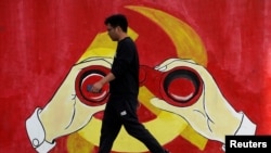 一名男子從上海街頭中共黨徽前走過。 （2019年9月25日）
