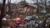An emergency vehicle drives through a neighborhood in Rowlett, Texas, Dec. 27, 2015, the morning after it was struck by a tornado. 