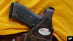Seorang pria memakai pistol yang tidak diturunkan di Austin, Texas, 14 April 2018. (Foto: AP)