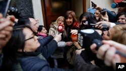 Former President Cristina Fernandez is surrounded by media outside her home as she leaves for a court hearing, in Buenos Aires, Argentina, Aug. 13, 2018.