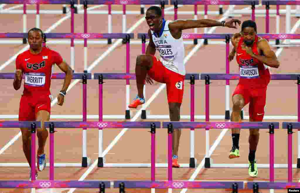 Dayron Robles (center), of Cuba, pulls up after injuring his leg while competing with Aries Merritt (L) and Jason Richardson of the U.S. during the men's 110m hurdles final.